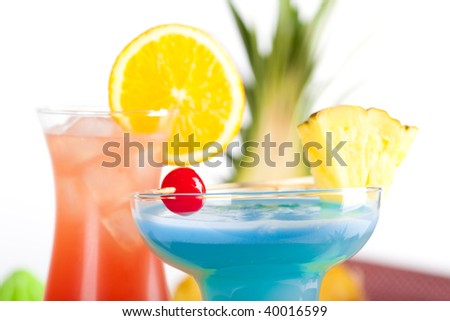 Two tropical cocktails with pineapple, orange and cherry