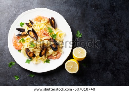 Pasta with seafood on stone table. Mussels and prawns. Top view with copy space