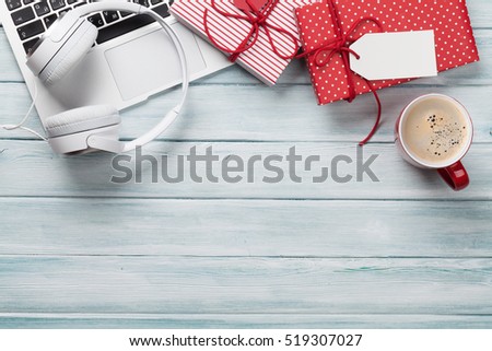 Christmas gift boxes, laptop, headphones and coffee cup on wooden background. Top view with copy space for your text