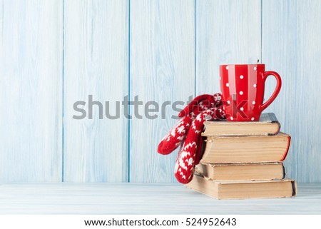 Hot chocolate cup and mittens over books. Christmas. View with copy space