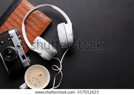 Office leather desk table with headphones, camera and coffee. Top view with copy space