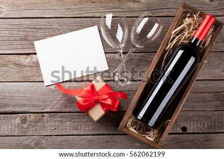 Valentines day greeting card. Wine and gift box on wooden table. Top view with copy space
