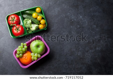 Lunch box with vegetable and fruits on stone table. Top view with copy space