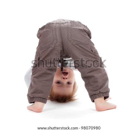 Small baby stands on head. Isolated on white background