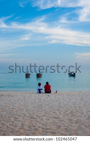 KO LIPE, THAILAND - JANUARY 24, 2010: A couple shares a quiet moment on the beach on January 24, 2010 in Ko Lipe, Thailand. Ko Lipe has shot to fame after being in National Geographic Best Trips 2012