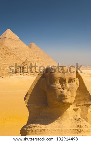 A beautiful composite of the Giza pyramids behind a closeup of the head of the great Sphinx in Cairo, Egypt