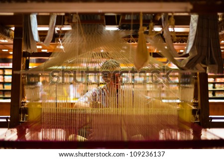 TIRUNELVELI, INDIA - DECEMBER 9: A unidentified Indian man makes a traditional sari to demonstrate a hand loom on December 9, 2009 in Tirunelveli, India. Textile industry is important for India