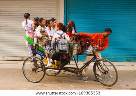 DELHI, INDIA - OCTOBER 27,: Unidentified girls ride a crammed private cycle rickshaw to school on October 27, 2009 in Delhi, India. Schools do not provide shared bus transportation in India.