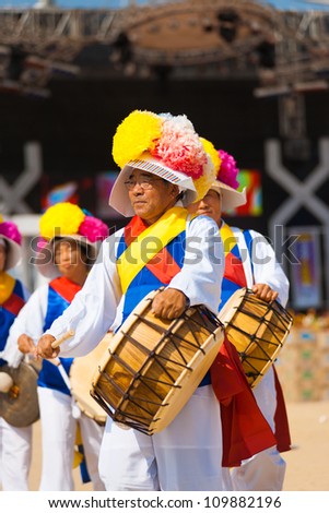 SEOUL, KOREA - SEPTEMBER 18: An older unidentified man plays a traditional Korean drum in colorful clothes at a local outdoor festival on September 18, 2009 in Seoul, Korea