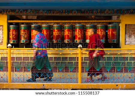DHARAMSALA, INDIA - JUNE 22: Buddhists in motion blur, spin prayer wheels near the home of the Tibet\'s Dalai Lama, a pilgrimage point, on June 22, 2009 in Dharamsala, India