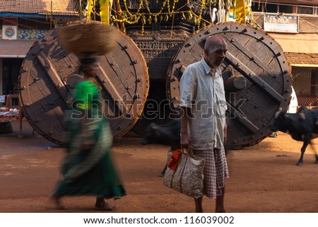 GOKARNA, INDIA - MARCH 2: A hindu man with painted face stands in front of a large chariot, ratha, an important device during festivals including Shivaratri on March 2, 2009 in Gokarna, India