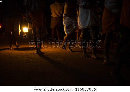 GOKARNA, INDIA - MARCH 26: Unidentified Indian men pull a ratha chariot by the light of a lantern on a primitive dirt road during a monthly hindu festival, on March 26, 2009 in Gokarna, India