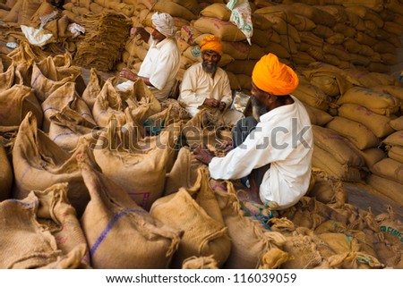 PAONTA SAHIB, INDIA - MAY 23: Unidentified Sikh men pack sacks full of charity grain in part of their philanthropic religious duties to help the needy on May 23, 2009 in Paonta Sahib, India