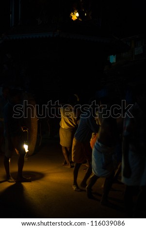 GOKARNA, INDIA - MARCH 26: Unidentified Indian men pull a ratha chariot by the light of a lantern on a primitive dirt road during a monthly hindu festival, on March 26, 2009 in Gokarna, India
