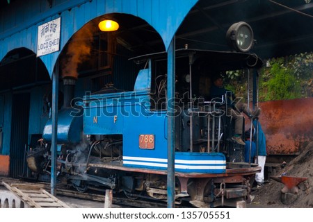 DARJEELING, INDIA - DECEMBER 27: An unidentified Indian driver sits in the rear of a parked toy train engine, a tourist attraction, in its shed on December 27, 2007 in Darjeeling, India
