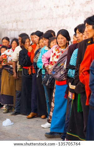 LHASA, CHINA - OCTOBER 17: Unidentified Tibetans in traditional clothes queue to enter Jokhang temple, a famous tourist attraction, pilgrimage site in Tibet on October 17, 2007 in Lhasa, China
