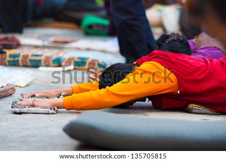 LHASA, CHINA - OCTOBER 17: An unidentified Tibetan prostrator lies flat on stomach with oustretched arms at Jokhang temple, a famous pilgrimage site in Tibet on October 17, 2007 in Lhasa, China