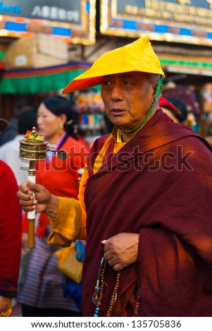 LHASA, CHINA - OCTOBER 17: An unidentified Tibetan Buddhist monk spins a prayer wheel circumambulating Jokhang temple, a tourist, pilgrimage site in Tibet on October 17, 2007 in Lhasa, China