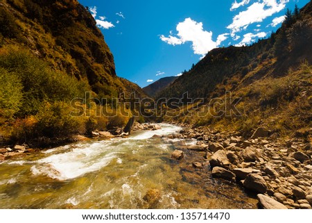 An ice cold alpine stream from the himalayas flows alongside the rarely seen G318 highway, a road that travels from east Tibet to Lhasa, through the heart of the Tibetan plateau. Horizontal