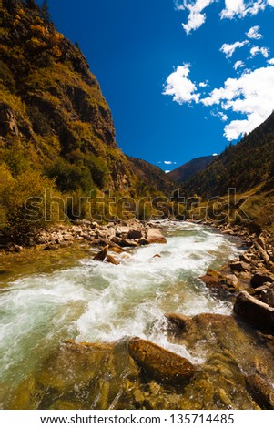 An ice cold alpine river from the himalayas flows alongside the rarely seen G318 highway, a road that travels from east Tibet to Lhasa, through the heart of the Tibetan plateau. Vertical