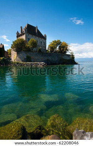 The beautiful floating French castle in Yvoire, France is anchored by partially submerged rocks and Lake Geneva\'s fresh waters.
