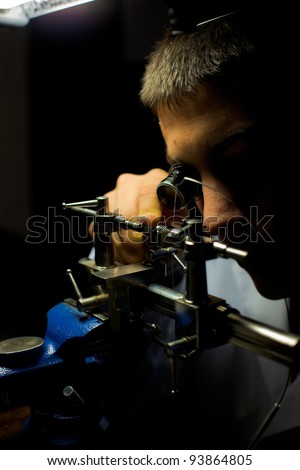 GENEVA, SWITZERLAND - NOV. 13: A Swiss watchmaker uses a lathe to grind a tiny watch part during The Watches Day, an annual exhibition of Swiss watchmakers November 13, 2011 in Geneva, Switzerland