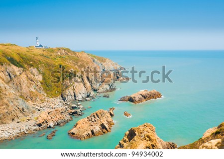 Picturesque cliffs, ocean and headland landscape and Dongju lighthouse on Juguang Island on the Matsu Islands of Taiwan.  Horizontal