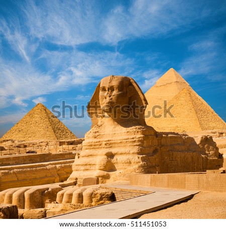 Egyptian Great Sphinx full body portrait with head, feet with all pyramids of Menkaure, Khafre, Khufu  in background on a clear, blue sky day in Giza, Egypt empty with nobody. copy space