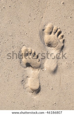 Adult foot prints in the sand. Both the prints are of the left leg.