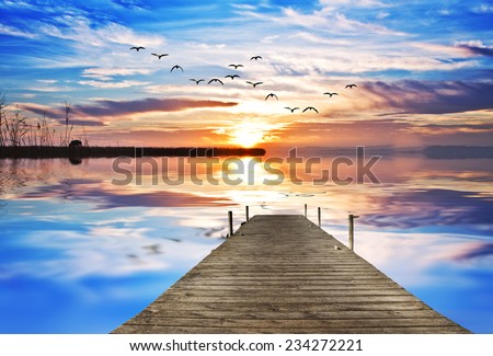 wooden pier on one side filled with colorful clouds