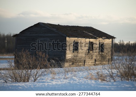 Log cabin in snow covered field at Hecla Grindstone Provincial Park, Manitoba, Canada