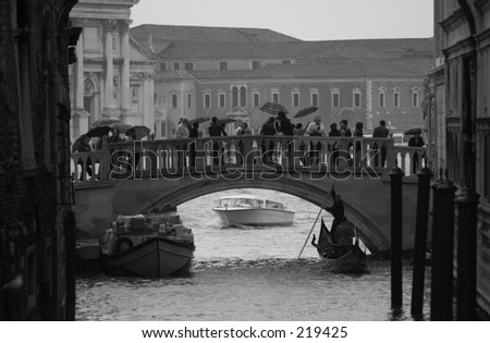 People walking on abridge over a canal, Venice, Italy (black and white)