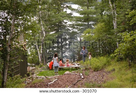 Family around camp fire, Lake of the Woods, Canada
