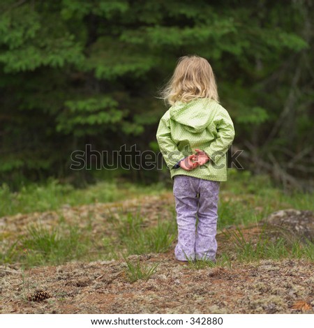 Rear view of a young girl standing in the woods with her hand behind her back, August 2004 (Keith Levit)