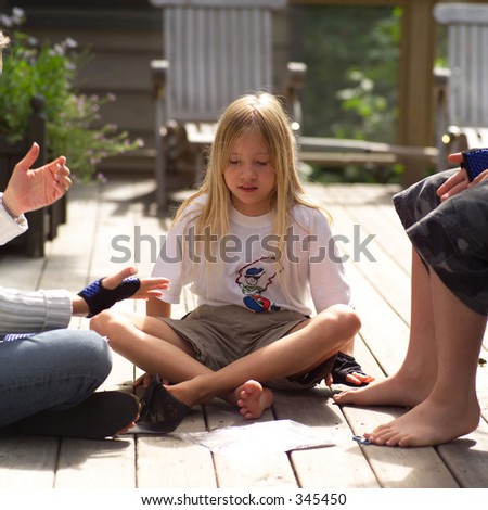 Young girl sitting with friends on a porch,
