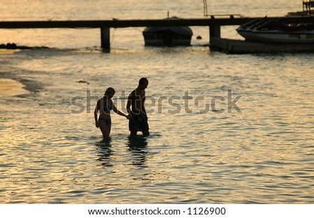A young couple wading into the sea, Moorea, Tahiti, French Polynesia, South Pacific