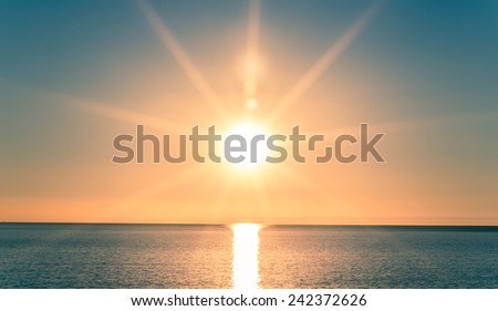 Sunset over Ocean - Bright Orange Sun Setting on Beautiful Blue Water
