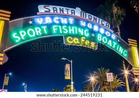 SANTA MONICA - JAN 14, 2015: Famous Glowing Santa Monica Yacht Harbor Sign - Entrance to Santa Monica Pier on Ocean Avenue in LA California at Night. Santa Monica is a beachfront city in Los Angeles.