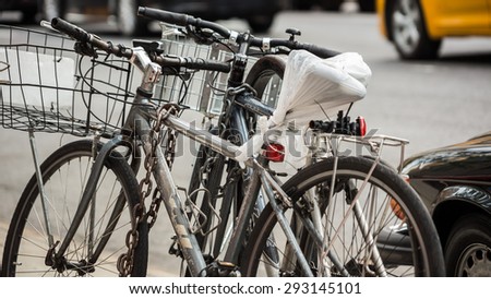 NEW YORK - JULY 19, 2014: chained bicycles parked on Manhattan, New York City street, in NY. Delivery persons and messengers use bicycles for transportation throughout the 5 boroughs of New York.