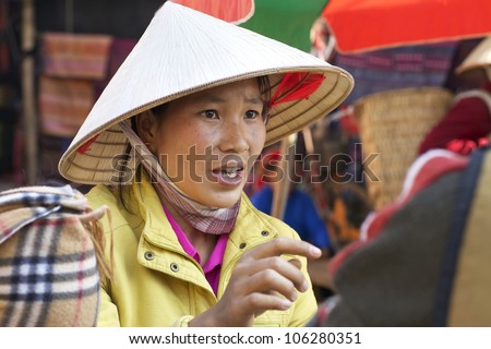 BAC HA, VIETNAM - NOV 21: Unidentified Vietnamese woman selling clothes at market on November 21, 2010 in Bac Ha, Vietnam. The Sunday market is the largest ethnic market in Lao Cai Province, Vietnam