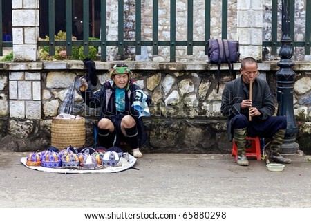 SAPA, VIETNAM - NOV 22: Unidentified woman from the H\'mong Ethnic Minority People and man playing flute on November 22, 2010 in Sapa, Vietnam.  H\'mong are the 8th largest ethnic group in Vietnam