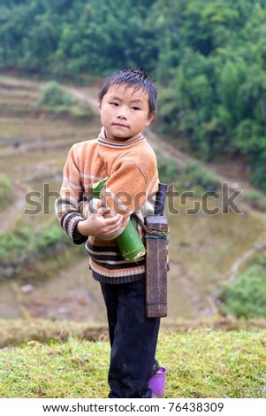 SAPA, VIETNAM, NOVEMBER 22: Unidentified young boy of the Black H\'mong Ethnic Minority People carrying toy in Sapa, Vietnam on November 22, 2010. H\'mong are the 8th largest ethnic group in Vietnam