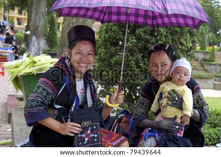 SAPA, VIETNAM - JULY 7: Unidentified women from the Black H\'mong Ethnic Minority People hold a baby on July 7, 2007 in Sapa, Vietnam. H\'mong are the 8th largest ethnic group in Vietnam