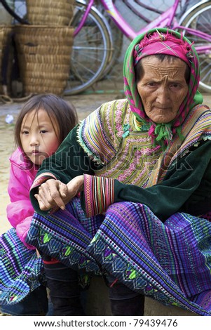 BAC HA, VIETNAM - NOV 21: Unidentified woman and girl from the Flower H\'mong Ethnic Minority People walk on November 21, 2010 in Bac Ha, Vietnam. H\'mong are the 8th largest ethnic group in Vietnam