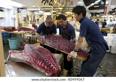 TOKYO- JULY 4: Workers processing Tuna at the Tsukiji Wholesale Seafood and Fish Market in Tokyo Japan on July 4, 2011. Tsukiji Market is the biggest wholesale fish and seafood market in the world.