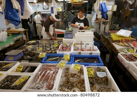 TOKYO- JULY 4: Seafood vendors at the Tsukiji Wholesale Seafood and Fish Market in Tokyo Japan on July 4, 2011. Tsukiji Market is the biggest wholesale fish and seafood market in the world.