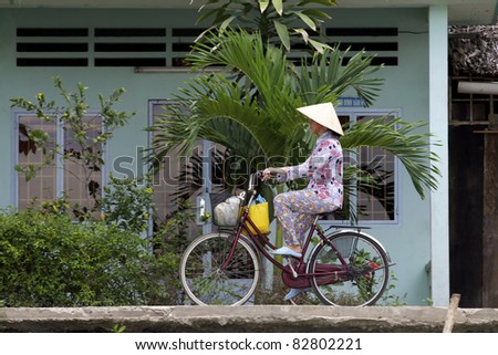 CAN THO, VIETNAM - MAY 28: Unidentified woman rides bicycle along Mekong in Can Tho, Vietnam on May 28, 2011. In 1999, Transportation Police Bureau estimated some 20 million bicycles in Vietnam.