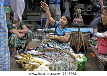 YANGON, MYANMAR - OCT 16: Street vendor sells chicken and fish in Yangon, Myanmar on October 16, 2011. Kyat, pronounced \