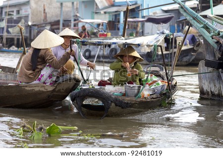 CAN THO, VIETNAM-JAN 7: Vietnamese woman selling cooked food from boat at the Floating Market in Can Tho, Vietnam on January 7, 2012. Cai Rang Market is the biggest floating market in the Mekong Delta