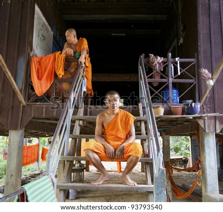 SIEM REAP, CAMBODIA - JAN 22: Unidentified Buddhist monks sitting on steps of home in Siem Reap on January 22, 2012. Buddhism is currently estimated to be the faith of 96% of the Cambodian population.